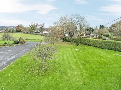 a field of green grass next to a road at Acorn Cottage in Kingsland