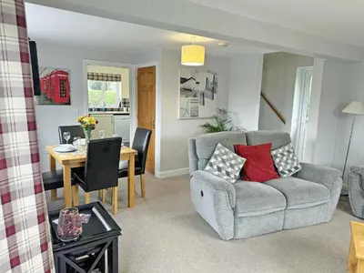 a living room with a couch and a table with a dining room at Acorn Cottage in Kingsland