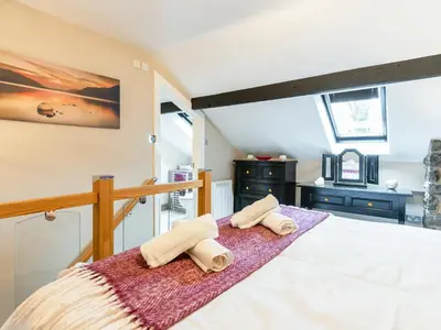a bedroom with a bed with towels on it at Ty Bach Twt in Dyffryn