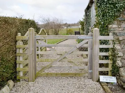 a wooden gate leading to a garden at Ty Bach Twt in Dyffryn