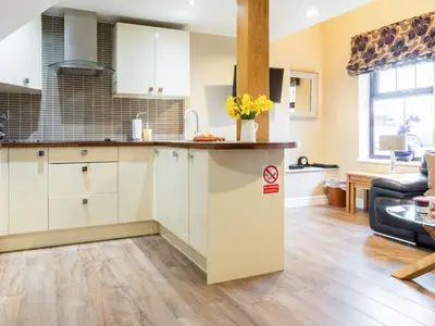 a kitchen with white cabinets and a counter top at Ty Bach Twt in Dyffryn