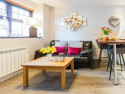 a living room with a couch and a table at Bwthyn Bach in Dyffryn