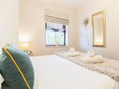 a bedroom with a white bed and a window at Bwthyn Bach in Dyffryn