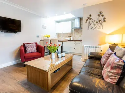 a living room with a couch and a coffee table at Bwthyn Clyd in Dyffryn