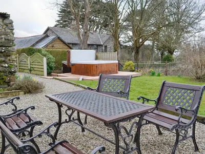 a picnic table and two chairs in a yard at Bwthyn Clyd in Dyffryn