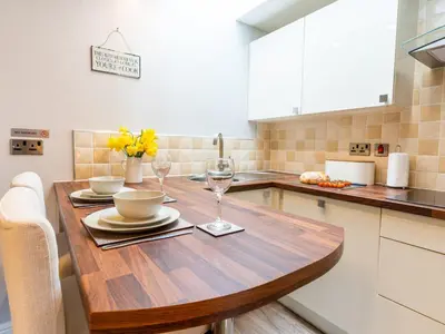 a kitchen with a wooden table with wine glasses at Bwthyn Clyd in Dyffryn