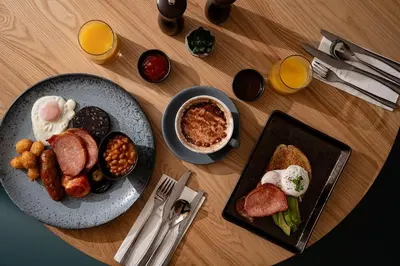 a wooden table with two plates of breakfast foods at Penrhos Park in Aberystwyth