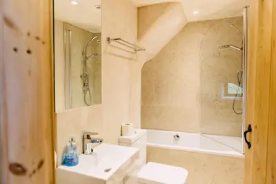 a bathroom with a sink and a shower and a toilet at Glyn Mawr Barn in Bala