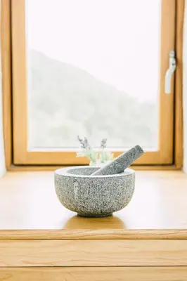 a stone bowl sitting on a table next to a window at Glyn Mawr Barn in Bala