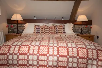 a bedroom with a large bed with two lamps at Cae'r Beili in Llandovery