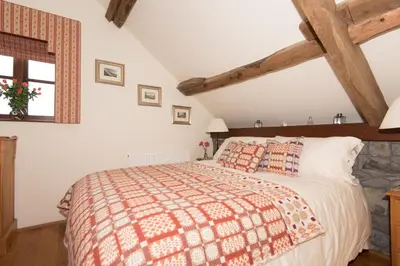 a bedroom with a large bed in a attic at Cae'r Beili in Llandovery