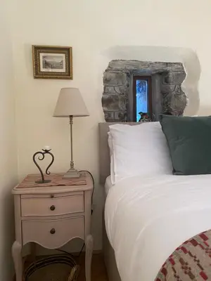 a bedroom with a bed and a table with a lamp at Cae'r Beili in Llandovery