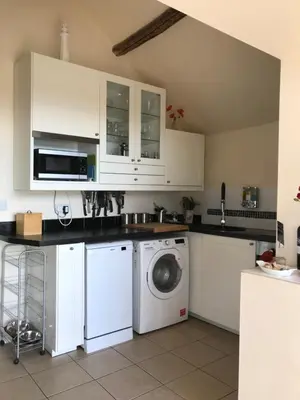 a kitchen with white cabinets and a washing machine at Beautiful Wales in Barmouth