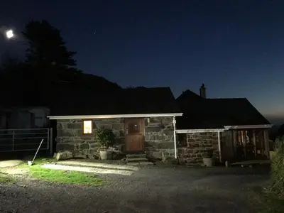a stone house with a door at night at Beautiful Wales in Barmouth