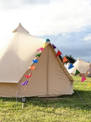 a tent is set up in a field at Glamping at Hay Festival in Hay-on-Wye