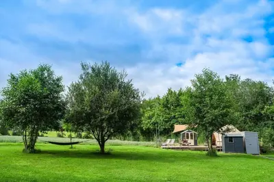 a house in the middle of a field with trees at Wye Glamping in Velindre