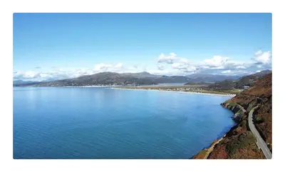 a large body of water with mountains in the background at The Moorings in Fairbourne