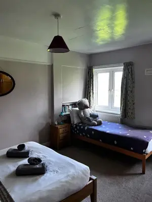 a bedroom with two beds and a teddy bear on the bed at The Moorings in Fairbourne