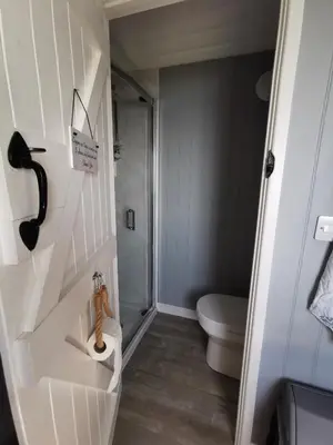 a small bathroom with a toilet and a sink at Allibella Shepherds Hut, Amazing Seaview, Private garden, Pet Friendly in Barmouth