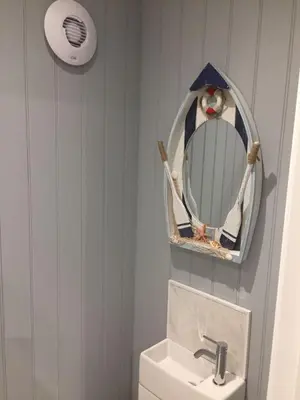 a bathroom with a mirror and a white toilet at Allibella Shepherds Hut, Amazing Seaview, Private garden, Pet Friendly in Barmouth