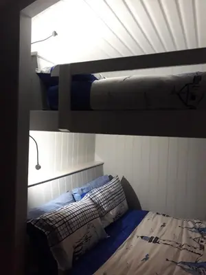 a bedroom with a bunk bed and a bed with a pillow at Allibella Shepherds Hut, Amazing Seaview, Private garden, Pet Friendly in Barmouth