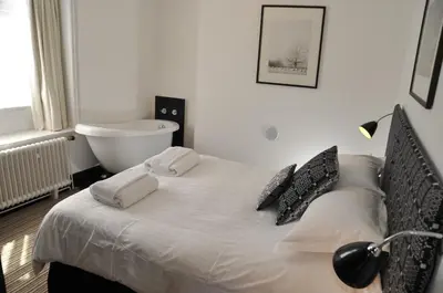 a bedroom with a bed and a bath tub at Greenbank Lodge LLANGOLLEN in Llangollen