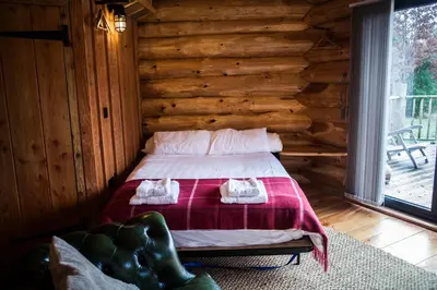 a bedroom with a bed in a log cabin at Coed y Marchog Woodland Retreat in Hereford