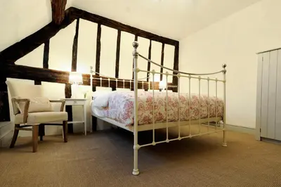 a bedroom with a poster bed and a chair at Lion & Pheasant Hotel in Shrewsbury