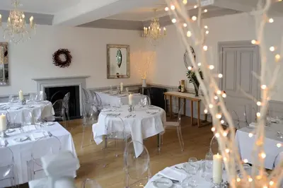 a room with white tables and chairs with lights at Lion & Pheasant Hotel in Shrewsbury