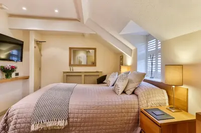 a bedroom with a large bed and a table at The Coach House Brecon in Brecon
