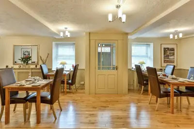 a dining room with wooden tables and chairs at The Coach House Brecon in Brecon