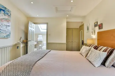 a bedroom with a large bed and a kitchen at The Coach House Brecon in Brecon