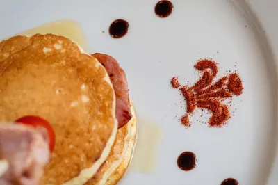 a white plate with pancakes and berries on it at The Coach House Brecon in Brecon