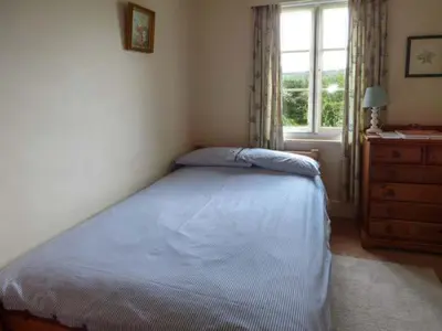 a bedroom with a bed and a dresser and a window at Fiddlers Green in Bucknell