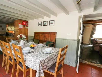 a dining room with a table and chairs at Penuwch Fach in Llanfihangel-y-creuddyn