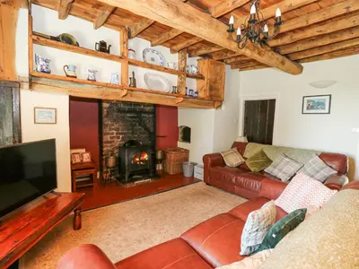 a living room with a couch and a fireplace at Penuwch Fach in Llanfihangel-y-creuddyn