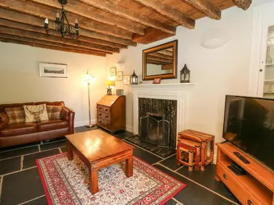 a living room with a tv and a fireplace at Penuwch Fach in Llanfihangel-y-creuddyn