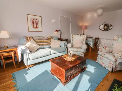 a living room with a couch and a table and chairs at Dolau Meurig in Ystrad Meurig