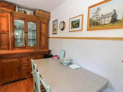 a dining room with a table and a cabinet at Dolau Meurig in Ystrad Meurig