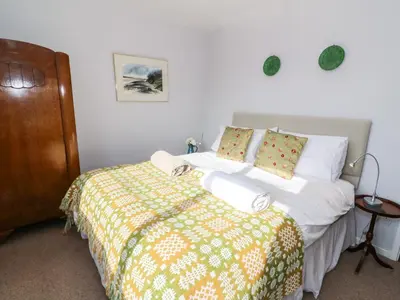 a bedroom with a bed with a yellow and green blanket at Dolau Meurig in Ystrad Meurig
