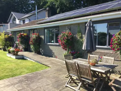 an umbrella sitting on a table in front of a house at Dolau Meurig in Ystrad Meurig