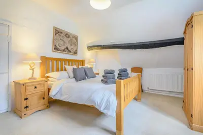 a bedroom with a bed with blue pillows on it at Fern Hall Cottage in Upper Welson