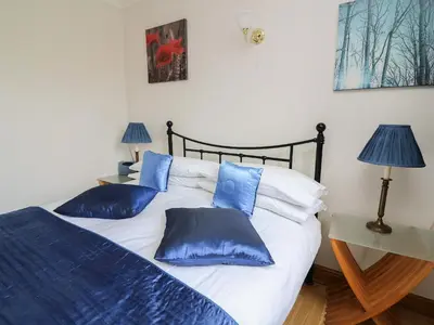 a bedroom with a bed with blue pillows on it at Blaenywawr Annexe in Cross Inn