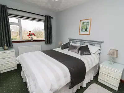 a bedroom with a large bed and a window at Blaenywawr in Cross Inn