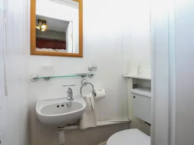 a bathroom with a sink and a toilet and a mirror at Maesawel Studio in Harlech