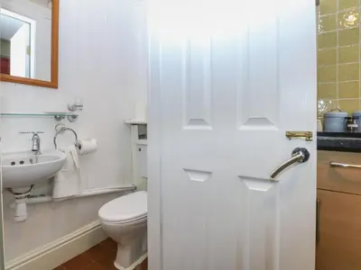 a white bathroom with a toilet and a sink at Maesawel Studio in Harlech