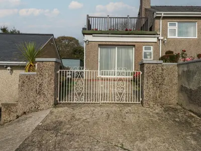 a gate to a house with a balcony at Maesawel Studio in Harlech