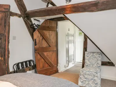 a bedroom with a barn door and a chair at Lower Hodre in Bucknell