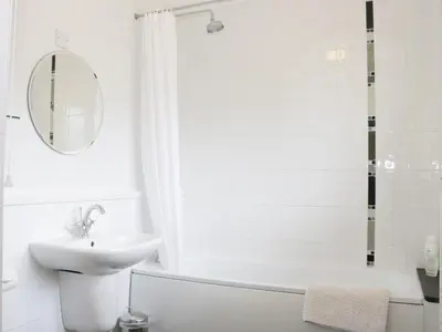 a white bathroom with a sink and a mirror at Acorn Cottage 1 in Petton