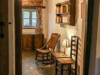 a hallway with two chairs and a table and a window at Pant Dafydd Goch in Glyn-Ceiriog